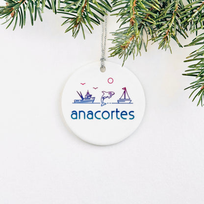 Round white ornament with 'anacortes' text and graphics, hanging on a Christmas tree.