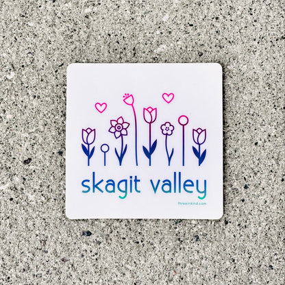 Sticker with floral design and 'skagit valley' text on a textured surface